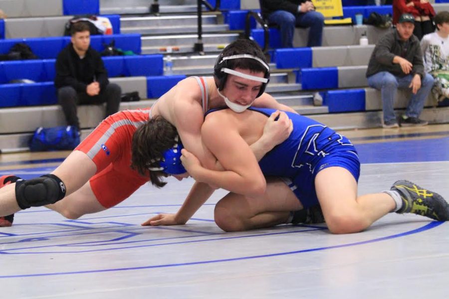 Aedan Somers attempts to force his opponent, Landon Kissell, onto his back. The match was close and went into overtime sudden victory. Somers opponent Kissell won the match after performing a take-down. Photo Credit: Julie Reid